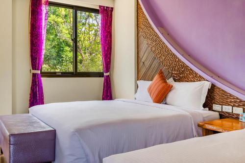 two beds in a room with a window at Southern Sun Homestay North in Kenting