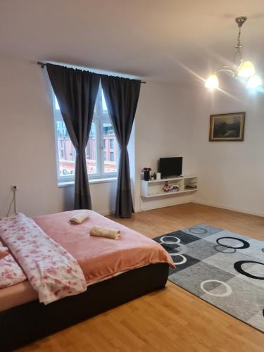 um quarto com uma cama e uma grande janela em Apartament Aga na Cracóvia