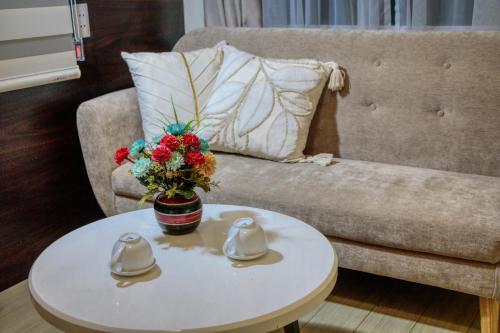 a coffee table with a vase of flowers on a couch at Hanoi Family Homestay in Hanoi