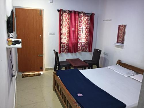 een slaapkamer met een bed en 2 stoelen en een raam bij Eastern Giri home stay in Attigundi