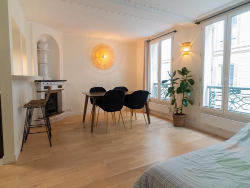 1 dormitorio con mesa y sillas en una habitación en Appartement d'architecte au cœur de Paris 9, en París