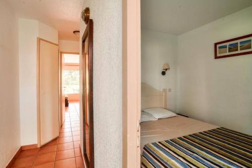 - une petite chambre avec un lit et un couloir dans l'établissement Le Domaine du Golf de Pinsolle - maeva Home - Appartement 2 pièces 5 personnes - Confort MAE-7414, à Soustons