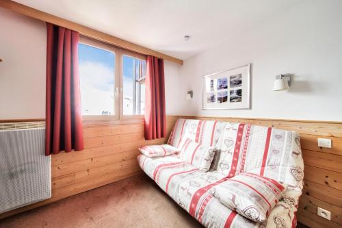 un salon avec un canapé et une fenêtre dans l'établissement Résidence Les Gémeaux - maeva Home - Studio 4 Personnes - Confort MAE-7474, à La Plagne Tarentaise