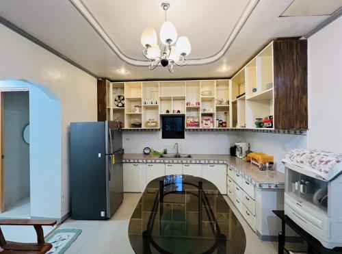 uma cozinha com armários brancos e um frigorífico preto em Zack's Cabin em Matinao