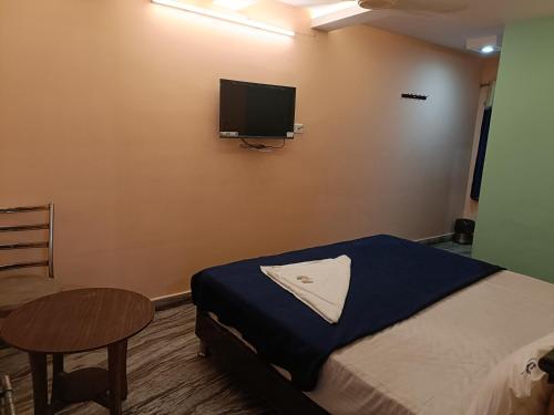 a bedroom with a bed and a tv on the wall at Hotel Dakshin Sea Paradise in Visakhapatnam