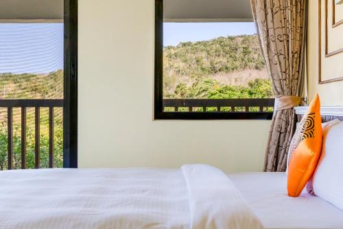 a bedroom with a bed and a large window at Southern Sun Homestay North in Kenting