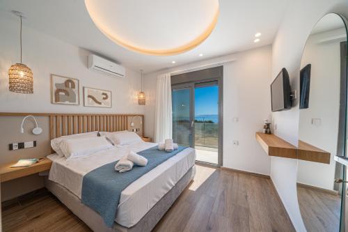 a bedroom with a bed and a desk and a window at Endless Blue Private Club in Trapezaki