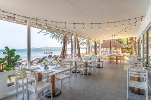 a restaurant with tables and chairs and a view of the ocean at Best Western Premier Bangtao Beach Resort & Spa in Bang Tao Beach