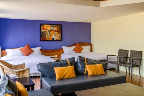 a living room with two beds and a couch at Southern Sun Homestay North in Kenting
