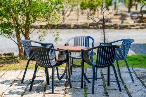 three chairs and a wooden table with a table and chairs at Southern Sun Homestay North in Kenting