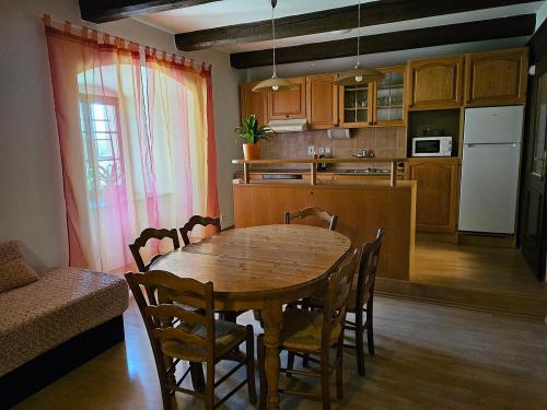 的住宿－Penzion Šiškův mlýn，厨房以及带木桌和椅子的用餐室。