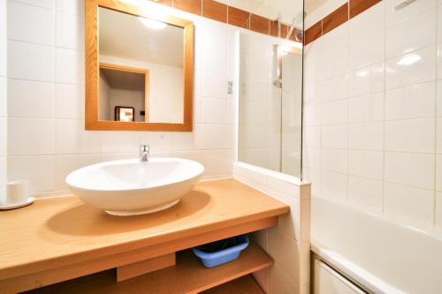 La salle de bains est pourvue d'un lavabo, d'un miroir et d'une baignoire. dans l'établissement Résidence Plagne Lauze - maeva Home - Appartement 3 pièces 6 personnes - S 674, à Mâcot La Plagne