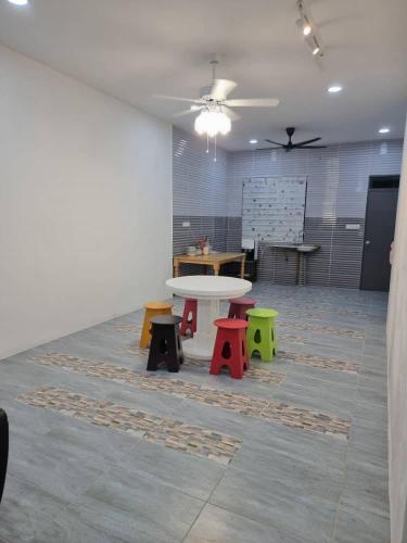 una habitación con una mesa y mesas coloridas. en Happy Living, en Sibu