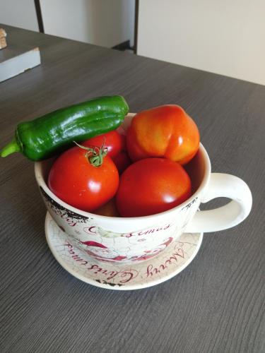 a bowl of tomatoes and a green pepper on a table at Chez Nath in Aubréville