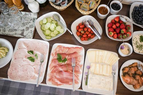 a table filled with different types of meats and vegetables at Pension Haus Tirol in Laion