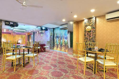 a restaurant with tables and chairs in a room at Hotel Red York By Byob Hotels in Noida
