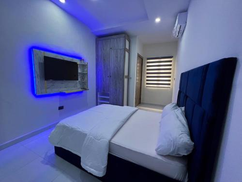 een slaapkamer met een bed met blauwe verlichting bij Honey homes in Lekki