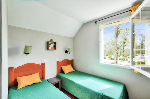 une petite chambre avec deux lits et une fenêtre dans l'établissement La résidence du Lac - maeva Home - Maison 3 pièces 6 personnes - Prestige MAE-3761, à Monflanquin