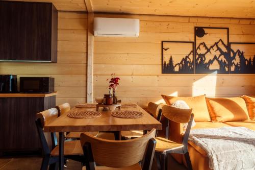 a dining room with a table and a bed at Domki Widokówki in Koniaków