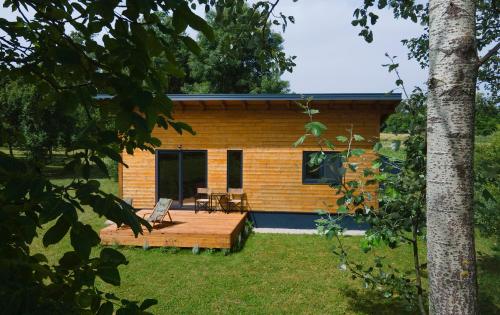 a small house with a wooden deck in the yard at Wooden house and modern container in Lekneno, near Zagreb in Lekneno