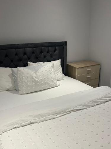 a white bed with a black headboard and white pillows at Spencer bridge Rooms by AFL in Northampton