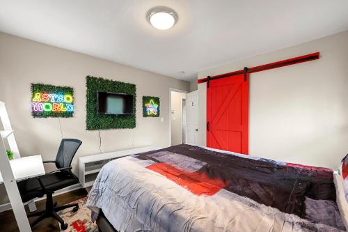 1 dormitorio con puerta roja, escritorio y cama en Good Vibes @ Astroworld by MARTA/Downtown/Midtown/Hartsfield-Jackson Airport, en Atlanta