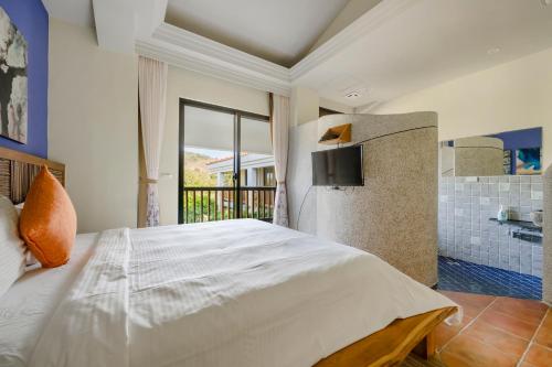 a bedroom with a large bed and a balcony at Southern Sun Homestay North in Kenting