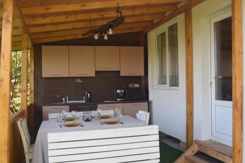 a kitchen with a white table and a dining room at Къща Виктория in Banya