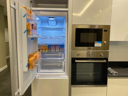einen Kühlschrank mit offener Tür in der Küche in der Unterkunft Falak Furnished Quarters in ‘Awālī