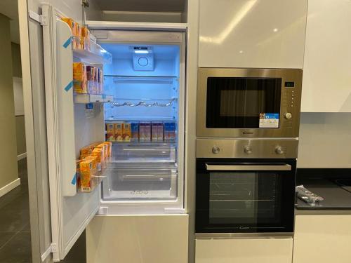 a refrigerator with its door open in a kitchen at Falak Furnished Quarters in ‘Awālī