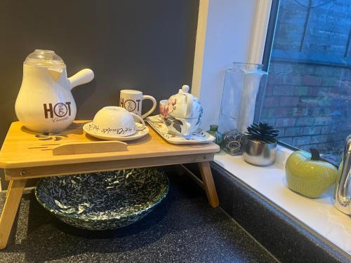 een tafel met een theepot en borden erop bij Spencer bridge Rooms by AFL in Northampton