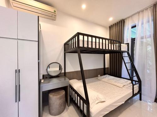1 dormitorio con 2 literas y espejo en MUN HOMESTAY, en Hue