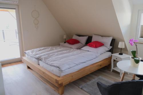 a bedroom with a bed with two red pillows at Bonnavista Ferienwohnungen in Großheubach