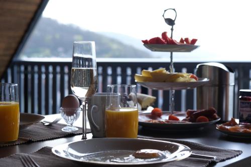 a table with a plate of food and glasses of orange juice at Bonnavista Ferienwohnungen in Großheubach