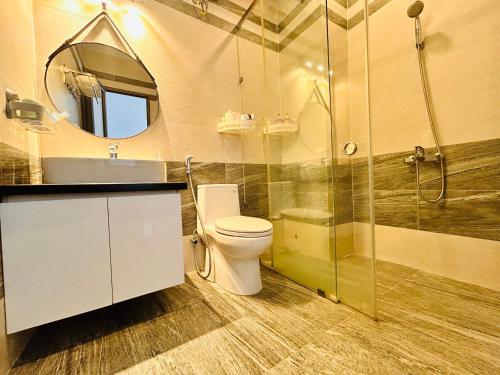 a bathroom with a toilet and a shower and a sink at MUN HOMESTAY in Hue