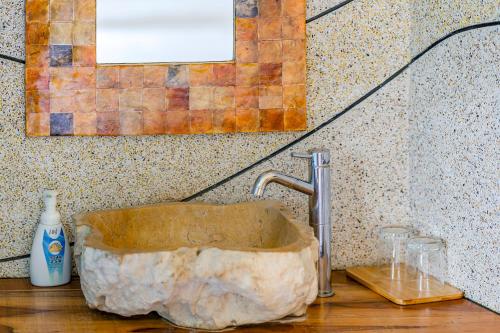 a stone sink in a bathroom with a wall at Southern Sun Homestay North in Kenting