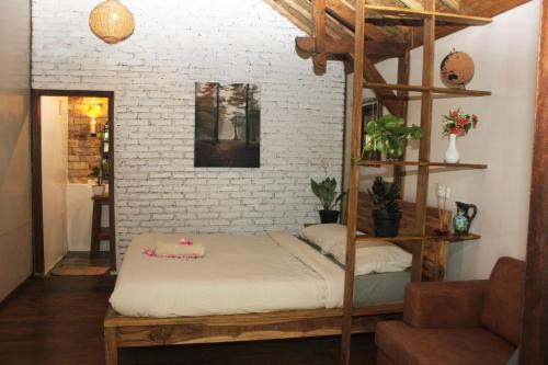 a bed in a room with a brick wall at Santai House in Tetebatu