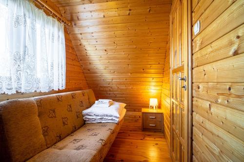 a small room with a bench in a wooden cabin at Omega Domki in Gąski