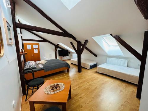 a attic room with two beds and a table at Penzion Podzámčí in Jaroslavice