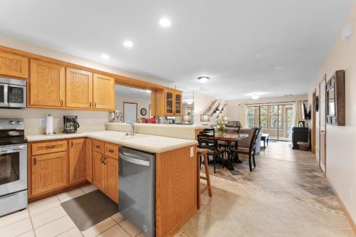 a kitchen with wooden cabinets and a dining room at Dog-Friendly Quiet Cove Condo in Hollister