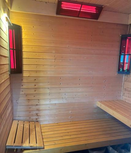 an empty sauna with a wooden wall and two windows at Brabants Genieten in Kaatsheuvel