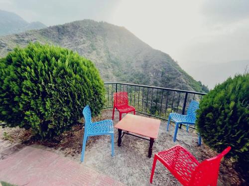 a group of chairs and a table on a balcony at The Himalaya Retreat Resort, Experience Nature in the Lap of Himalayas in Mussoorie