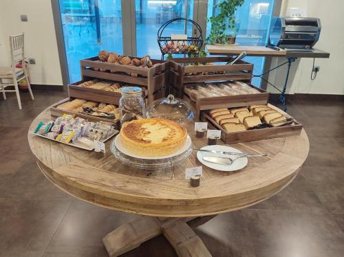 a wooden table with bread and pastries on it at Hotel Sercotel Cuatro Postes in Avila