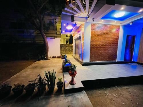 a house with blue lights and potted plants at Neems paradise in Point Pedro