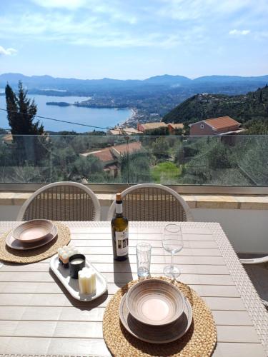 a table with plates and glasses and a bottle of wine at Villa Filothea with Jacuzzi and sea view in Spartýlas