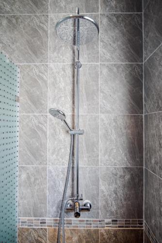a shower with a shower head in a bathroom at Oriental Beach Pearl Resort in Sam Roi Yot