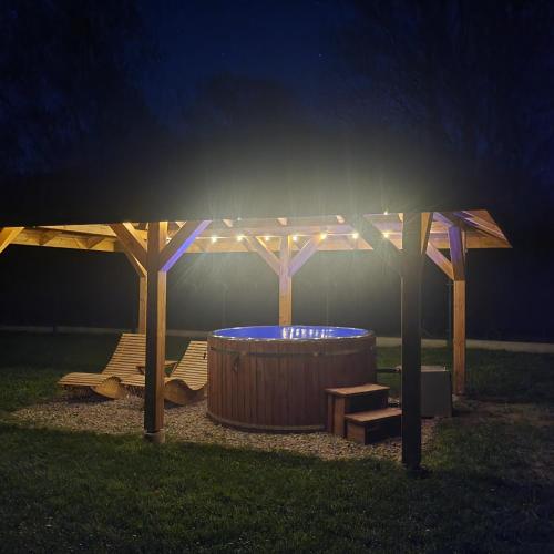 a gazebo with a hot tub in the grass at Glamping nad Sanem in Krzemienna