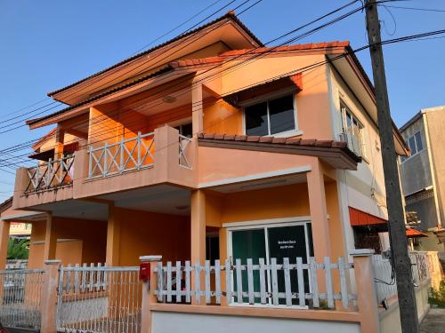 a house with a white fence in front of it at NUN GUEST HOUSE in Ban Bo Han
