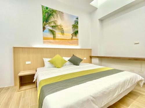 a bedroom with a large bed with a painting on the wall at 隱 the house in Magong