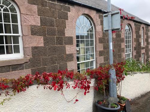 a building with red flowers on the side of it at Gallery Flat in Newburgh